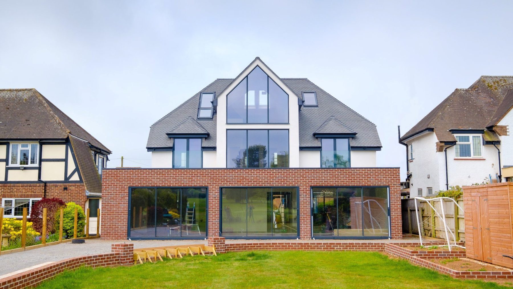 An external view of the brick rear extension with large glass sliding patio doors to a transformed 1930s detached family home on Topsham Road.