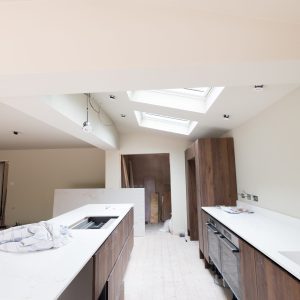 An internal view of the open plan kitchen at Nethercott in Silverton with a substantial kitchen island and new skylights above.