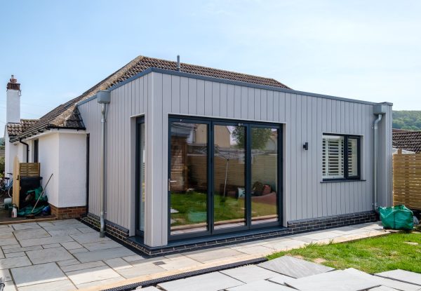 An external rear view of the modern extension to a freshly painted rendered bungalow in Sidford near Sidmouth.